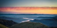 view of mountains and river at sunset