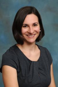 professional photo of a woman smiling against a blue background